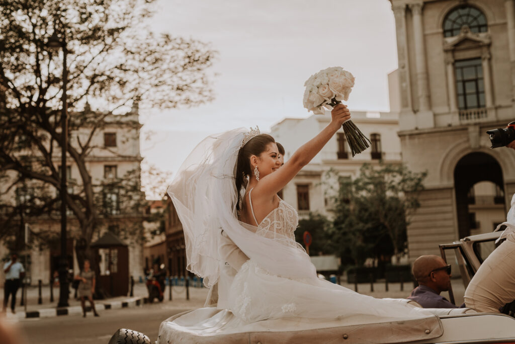 Novios pasean en auto antiguo por La Habana. Novios en auto descapotable en La Habana