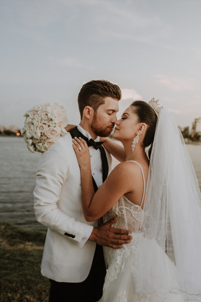 Novios posan para la cámara, luego de su ceremonia de bodas en La Habana. Se ve el mar de fondo. Boda en La Habana, Cuba